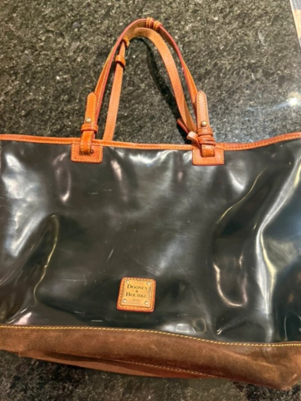Dooney & Bourke large black patent leather tote with leather handles.